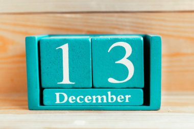 13 Aralık. Ahşap zemin üzerinde ay ve tarih olan mavi küp takvimi.