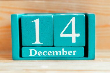 14 Aralık. Ahşap zemin üzerinde ay ve tarih olan mavi küp takvimi.