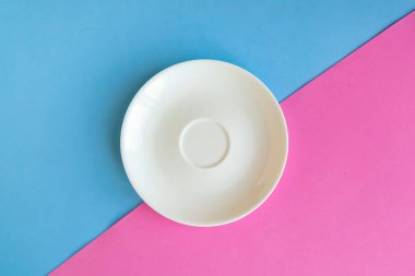 Mavi ve pembe arka planda boş bir tabak. Metin için alanı kopyala. Asgari konsept