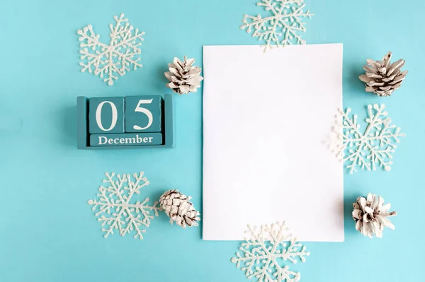 5 Aralık. Aylık ve tarihli mavi küp takvimi ve mavi arkaplanda beyaz model boş.