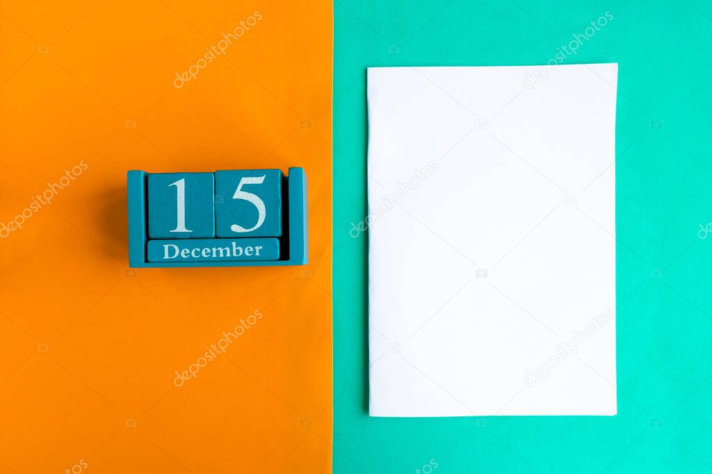 December 15. Blue cube calendar with month and date and white mockup blank on color background.