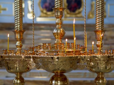 Mum çubuğunda kilise mumları yakmak. Kilisenin arka planı.