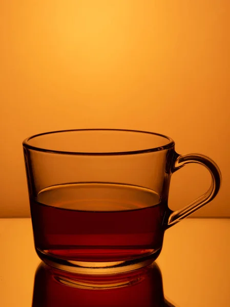 Schwarzer Tee Einem Glasbecher Auf Orangefarbenem Hintergrund — Stockfoto