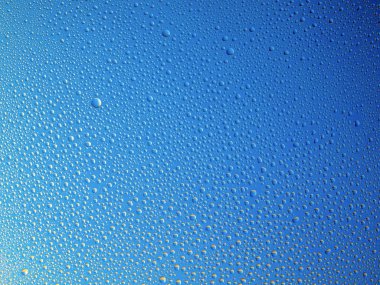 Camın üzerine renkli arka planda su damlacıkları. Su damlaları.