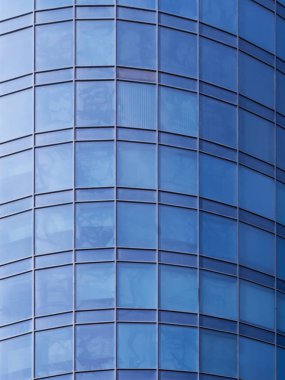 Mavi gökyüzü ile bina cephe. Modern mimaride cam duvar.