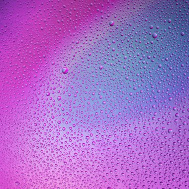 Camın üzerine renkli arka planda su damlacıkları. Su damlaları.