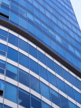 Mavi gökyüzü ile bina cephe. Modern mimaride cam duvar.
