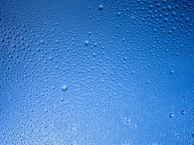 Camın üzerine renkli arka planda su damlacıkları. Su damlaları.