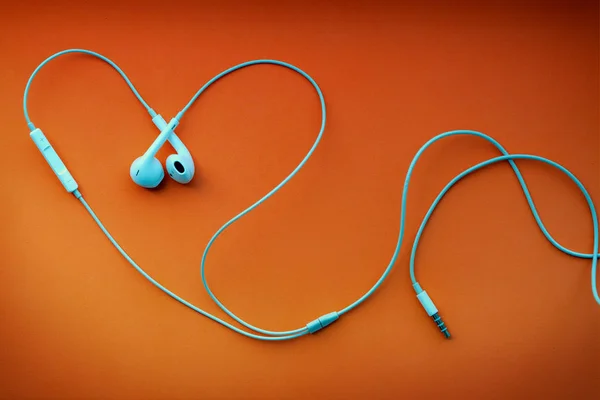 Λευκά Ενσύρματα Ακουστικά Ακουστικά Στο Σχήμα Της Καρδιάς Πορτοκαλί Φόντο — Φωτογραφία Αρχείου