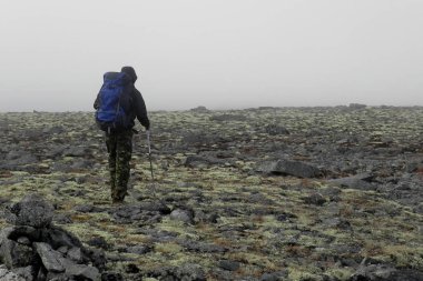 Dağlarda arkadan mavi sırt çantası olan bir adam. Khibinler.