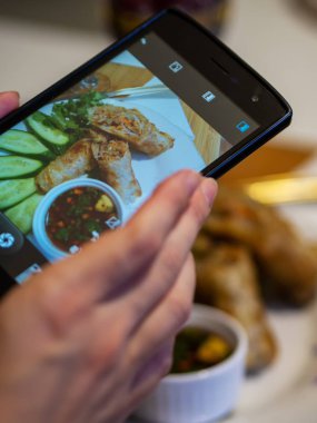 El kızarmış Vietnam krep fotoğraf lamak için bir akıllı telefon kullanarak - nem, sebze ile