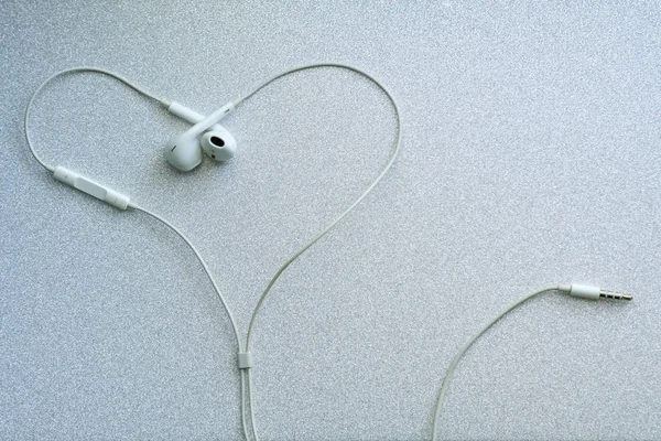 白色有线耳机 银色背景的心形耳机 音乐达 — 图库照片