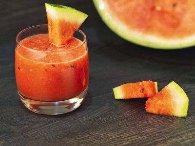 Cam bir kupa ve ahşap bir arka plan üzerinde karpuz dilimleri taze karpuz smoothie