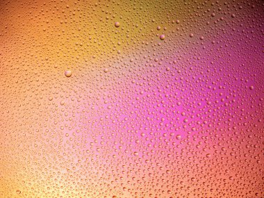 Camın üzerine renkli arka planda su damlacıkları. Su damlaları.