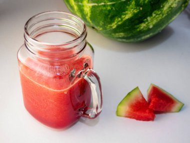 Cam bir kupa ve ahşap bir arka plan üzerinde karpuz dilimleri taze karpuz smoothie