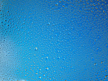 Camın üzerine renkli arka planda su damlacıkları. Su damlaları.