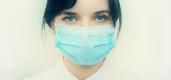 一个戴着保护性一次性医疗面具的年轻欧洲女人的画像 Caronavirus Cavid 19的概念和人类检疫戴面具的女孩在白墙上蒙面医务工作者 — 图库照片
