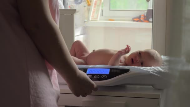 Mama kontrolliert das Babygewicht — Stockvideo