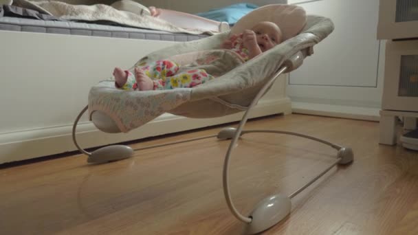 Wakker en actieve babymeisje in bouncy stoel thuis — Stockvideo