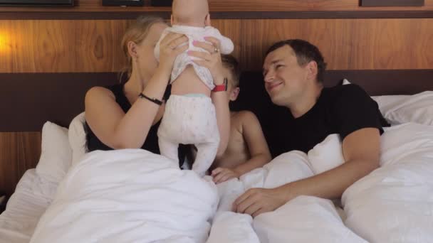 Ouders met baby en oudste zoon in bed — Stockvideo