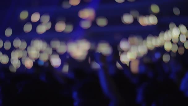 Толпа поклонников музыки с огнями в темном концертном зале — стоковое видео