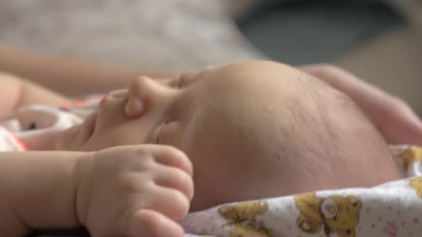 Бабуся гойдається спить дитина на колінах — стокове відео