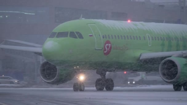 Airplane of S7 Airlines driving to runway in snowfall, Moscow — Stock Video