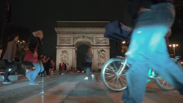 Orang-orang di persimpangan jalan dekat Arc de Triomphe di malam hari Paris — Stok Video