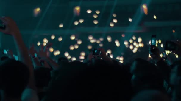 붐비는 불빛을 흔들며 콘서트에서 모바일 사진과 비디오를 만드는 사람들 — 비디오