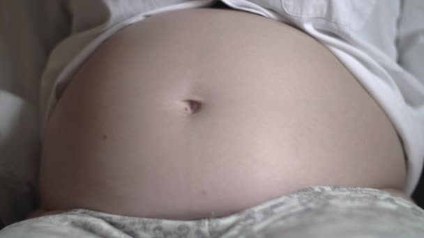 Herzförmige Hände auf schwangerem Bauch — Stockvideo