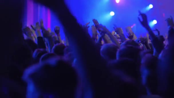 Cientos de personas emocionadas bailando en el concierto, vista con luces de escenario brillantes — Vídeo de stock