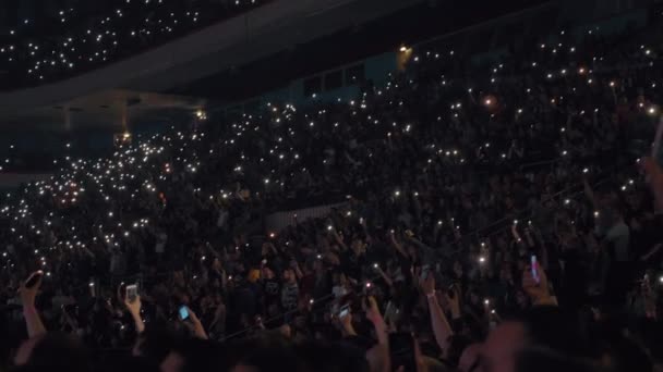 Les gens agitant des lampes de poche cellulaires au concert de musique — Video