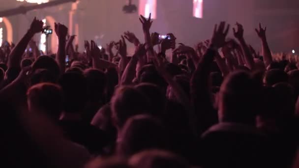 Audiencia vigorosa bailando con las manos en alto en el concierto — Vídeo de stock