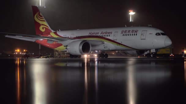 Hainan Airlines Boeing 787-8 Dreamliner припаркований в аеропорту вночі — стокове відео