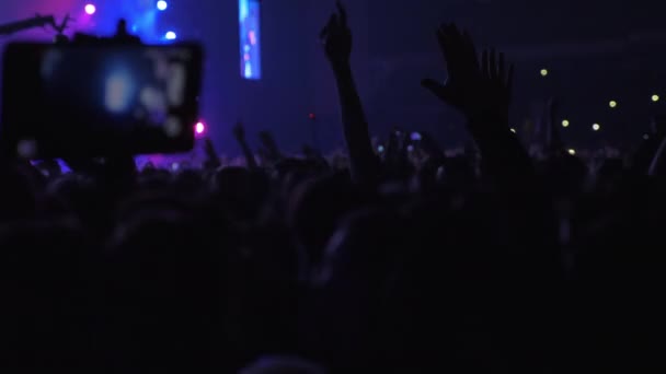 Сотни энергичных поклонников музыки на концерте — стоковое видео