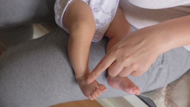 Mãe tocando pequenos dedos dos pés da querida filha bebê — Vídeo de Stock