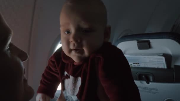 Ευτυχισμένο μωρό κόρη στο σκέλος μητέρες. Οικογενειακό ταξίδι με αεροπλάνο — Αρχείο Βίντεο