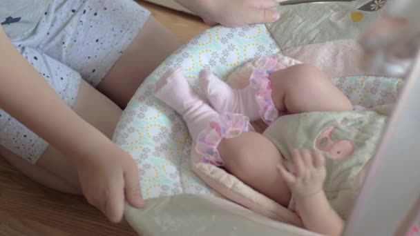 Hermano meciendo hermana pequeña en asiento hinchable — Vídeo de stock