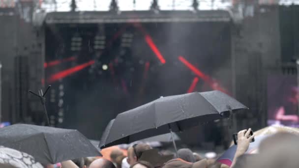 Szabadtéri koncert alatt az eső emberek — Stock videók
