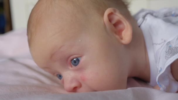 Портрет тихой симпатичной двухмесячной девочки с большими голубыми глазами — стоковое видео