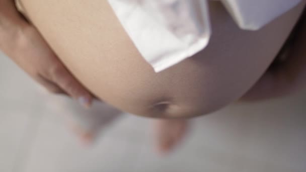Беременная женщина с руками на животе — стоковое видео