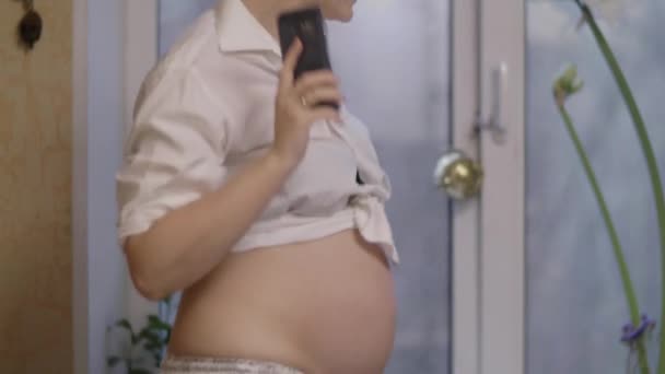 Femme enceinte être heureux et danser sur la musique de téléphone portable à la maison — Video