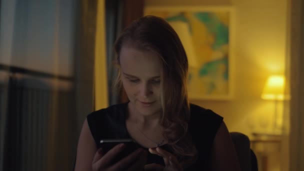 夕方自宅に携帯を持つ幸せな若い女性 — ストック動画
