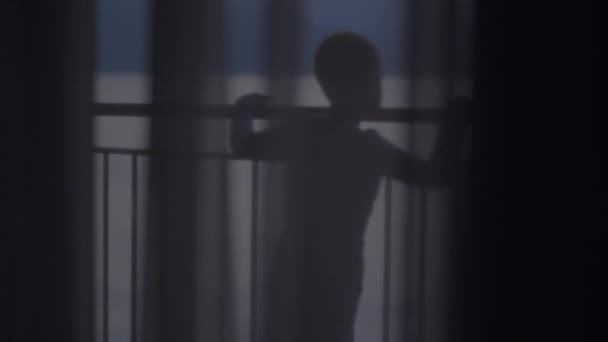 Barnet tittar på havet från balkongen — Stockvideo