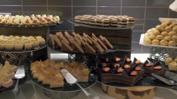 Um longo buffet com uma grande variedade de bolos e sobremesas — Vídeo de Stock