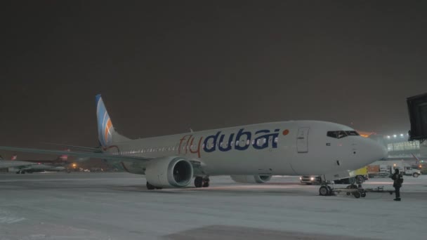 Припаркованный Boeing 737 MAX-8 FlyDubai в аэропорту Шереметьево в зимнюю ночь — стоковое видео