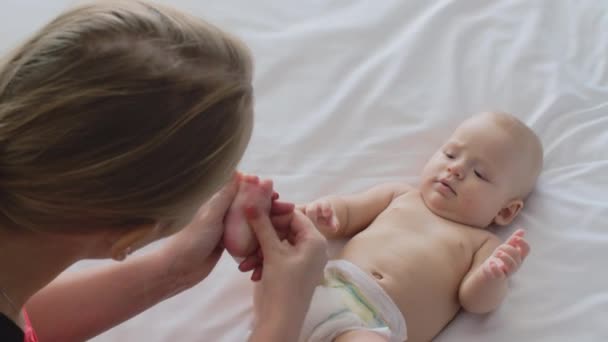 Bebek kız ayak masaj ve onunla oynamak bir kadın — Stok video