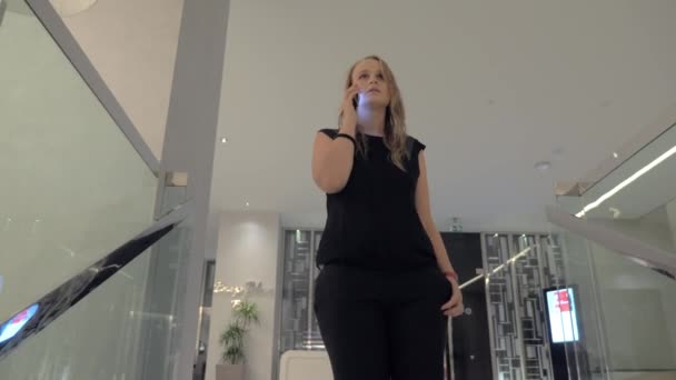 Una giovane donna che parla con uno smartphone mentre scende — Video Stock