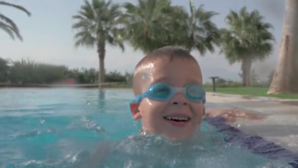 Enfant qui s'amuse dans la piscine pendant les vacances d'été — Video