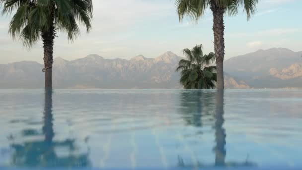 Resort scene with swimming pool, palms and mountains — Stock Video